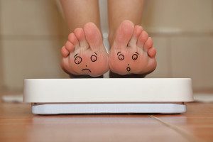 Feet on bathroom scale with hand drawn sad cute faces