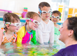 A group of children in a pool taking swimming lessons