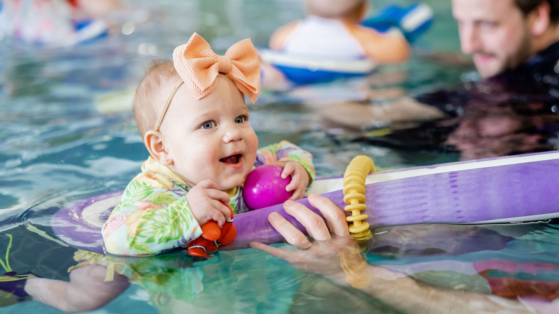 Baby in a swimming pool taking lessons