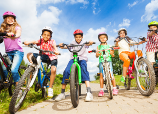 kids wearing bike helmets and riding bicycles on a sunny day